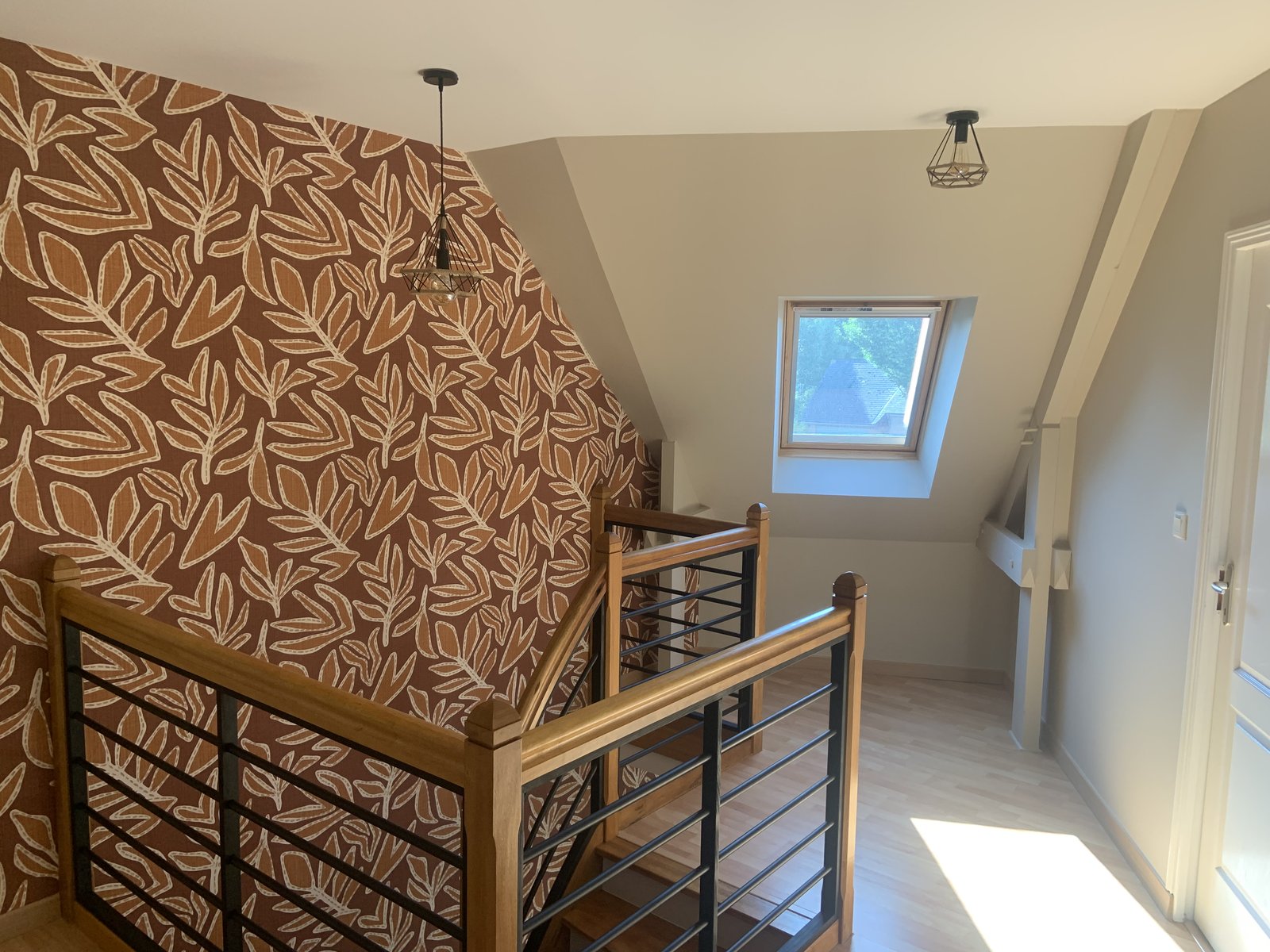 Pose de papier peint motif feuilles terracotta sur cage d'escalier